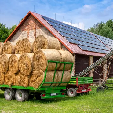 a trailer with bales of hay in front of a building