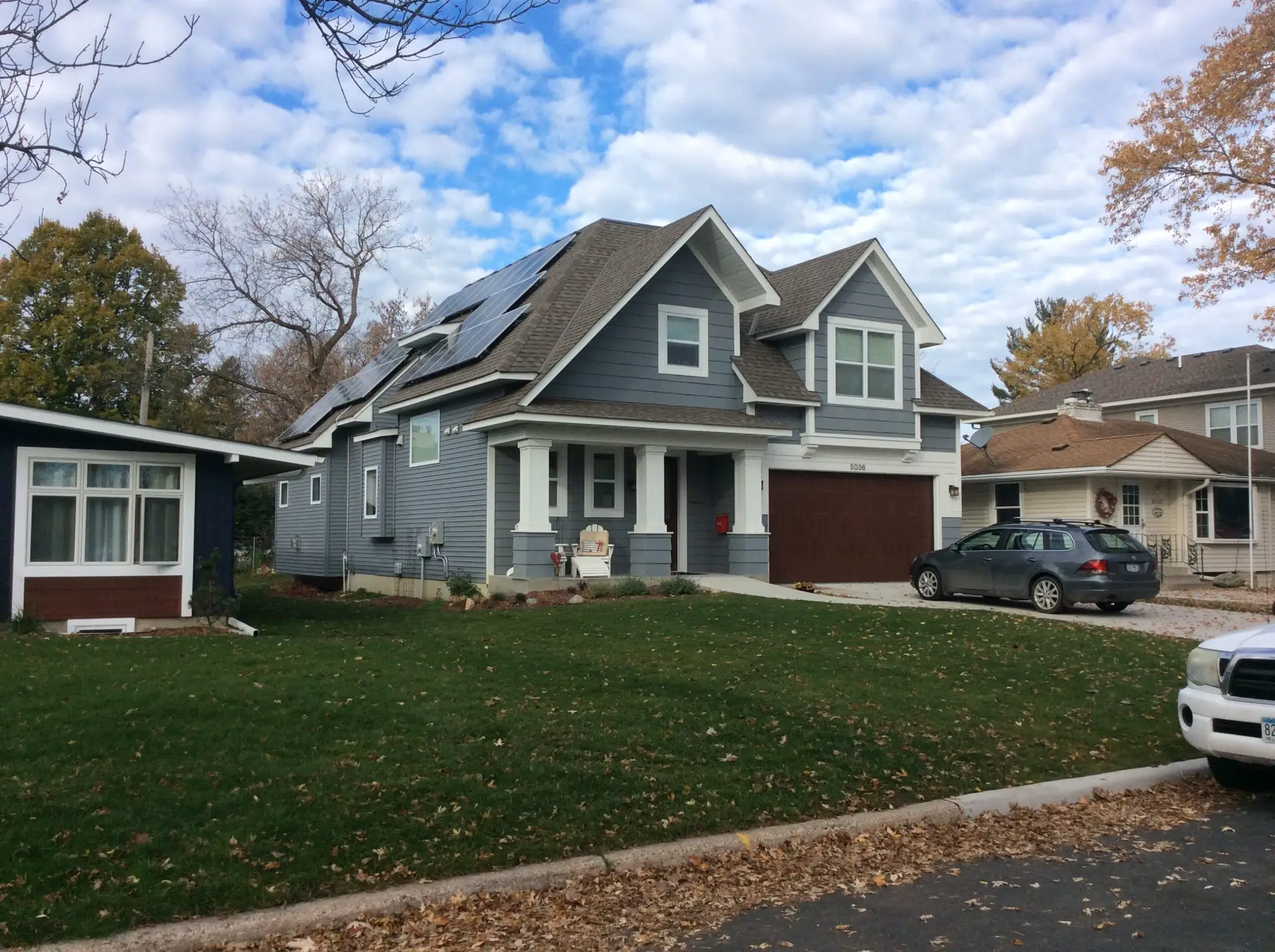 a house with a lawn and cars parked in front of it