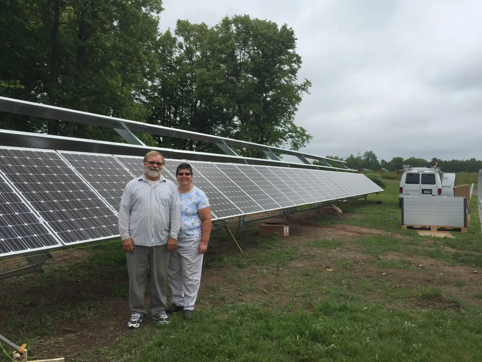 a man and woman standing in front of solar panels