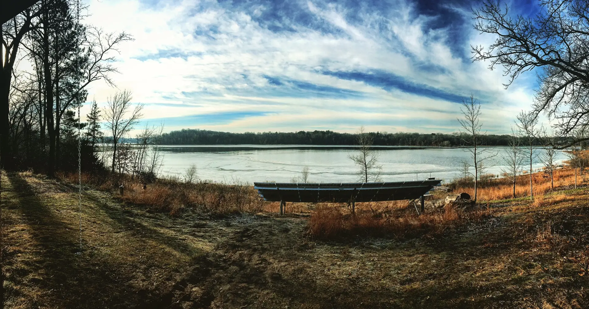 a lake with a bench and trees