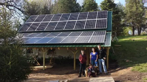 a group of people standing in front of a solar panel