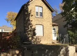 a house with a fence and trees in the background