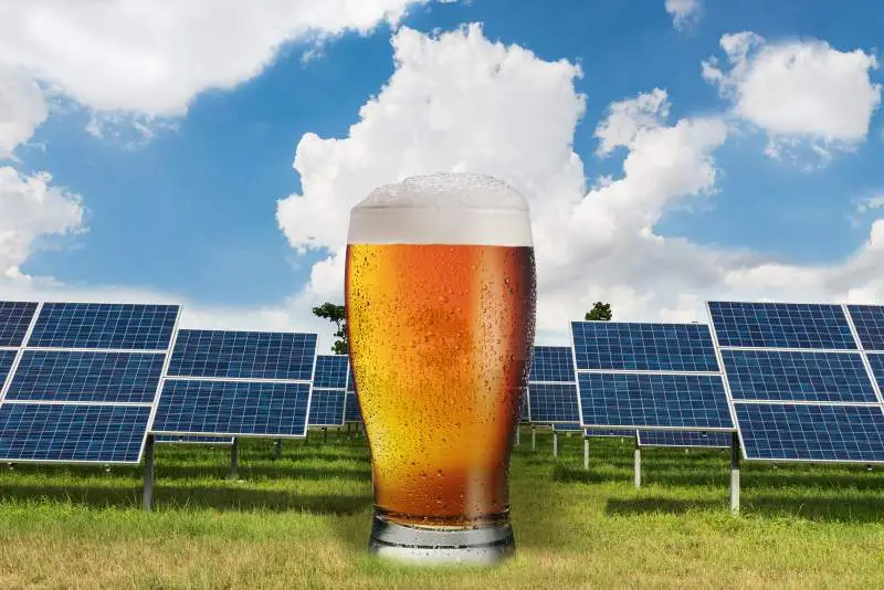 a glass of beer in front of solar panels