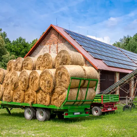 a trailer with bales of hay in front of a building