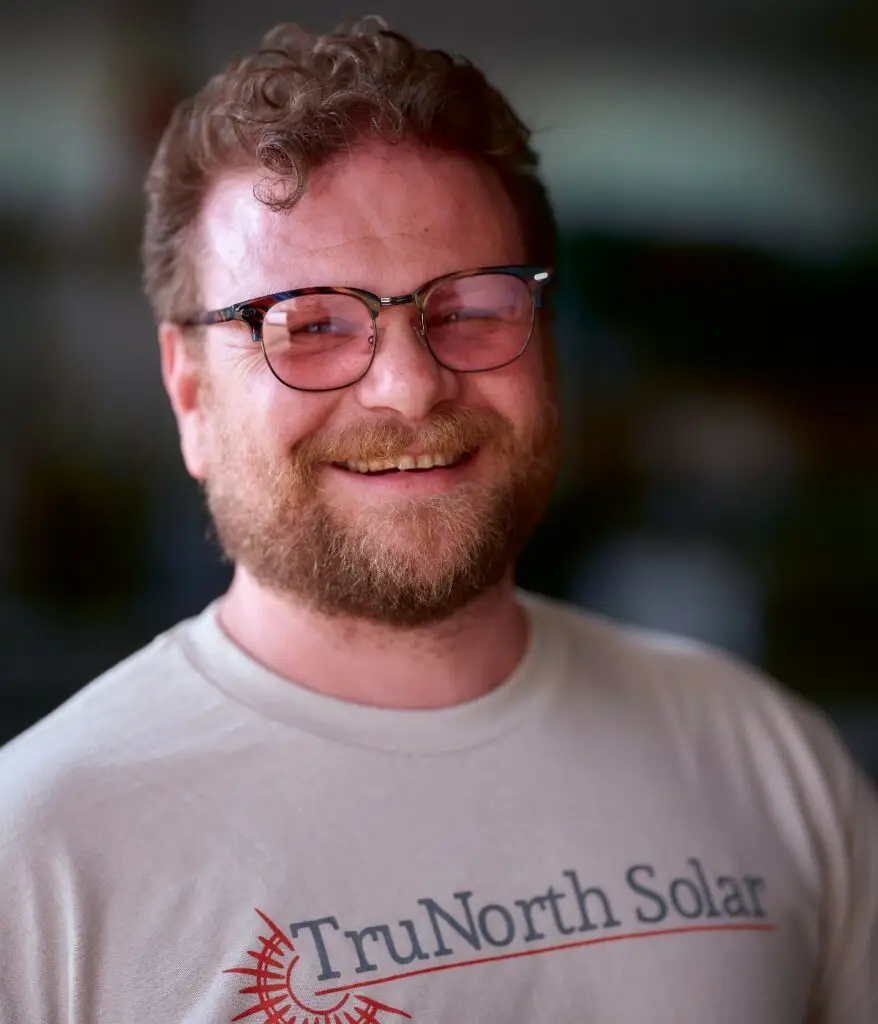 a man wearing glasses and smiling