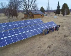 a group of people standing next to a solar panel