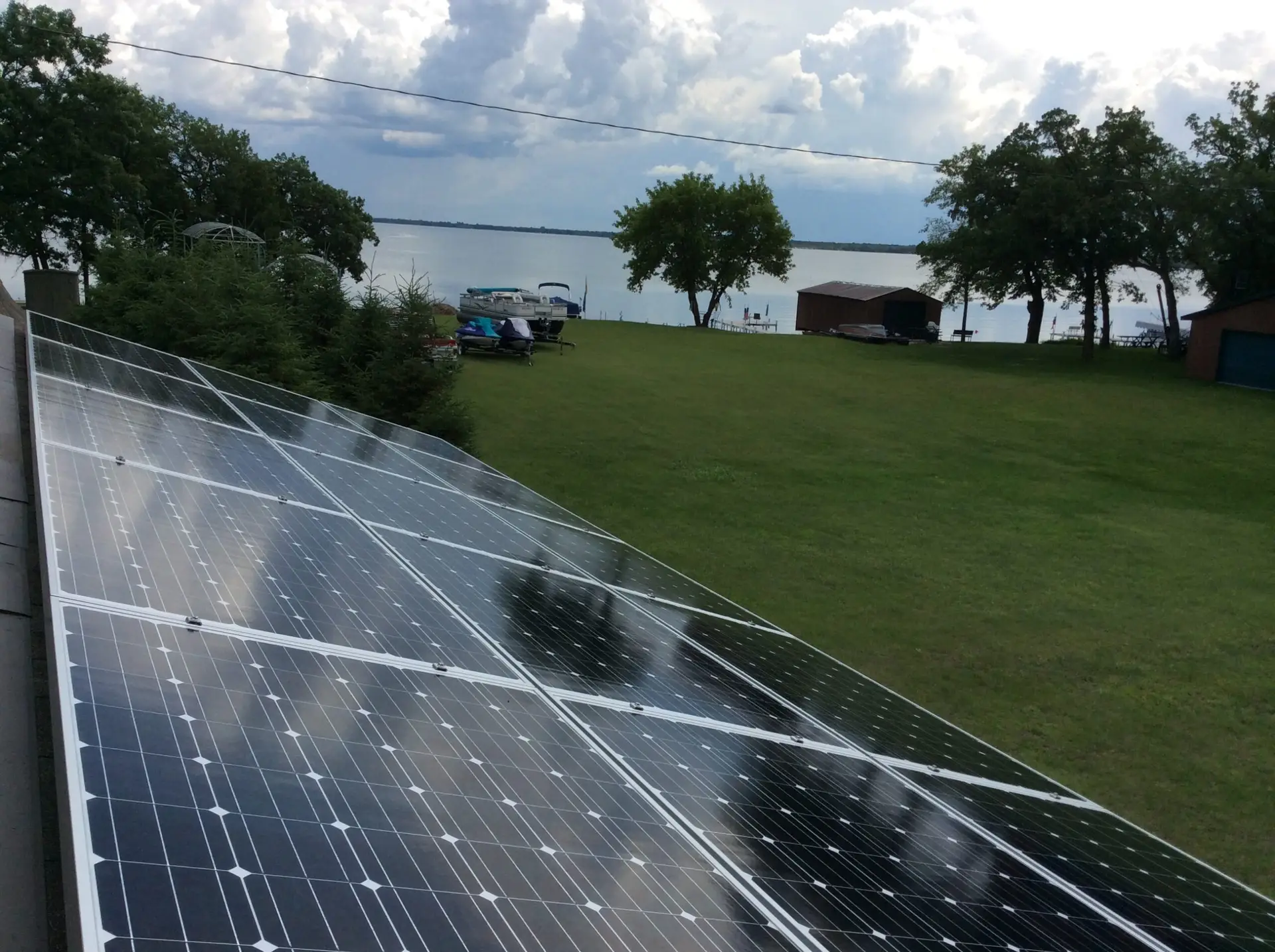 solar panels on a lawn by a lake