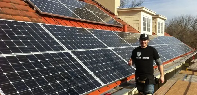 a man standing next to solar panels